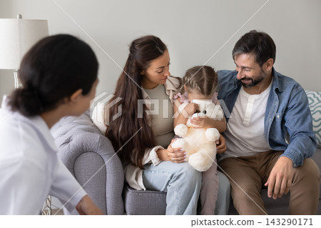 Little girl hiding face while parents and doctor comforting her Little girl hiding face while parents and doctor comforting her 143290171