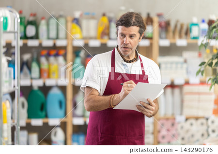 Adult man seller conducting inventory in store Adult man seller conducting inventory in store 143290176