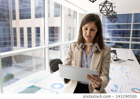 Focused Hispanic female manager working on tablet in planning room Focused Hispanic female manager working on tablet in planning room 143290500