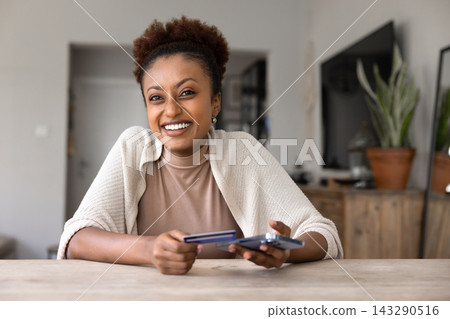 Portrait of African woman holding smartphone and credit card 143290516