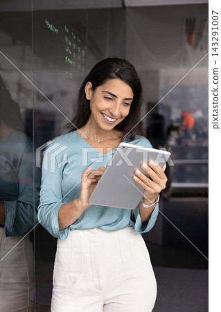 Cheerful businesswoman using digital tablet in modern office 143291007