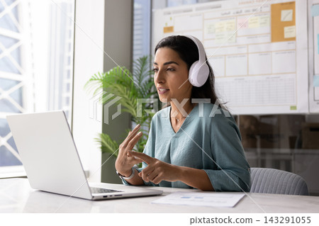 Young professional woman in headphones consulting client remotely Young professional woman in headphones consulting client remotely 143291055