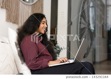 South Asian woman working remotely on laptop South Asian woman working remotely on laptop 143291164