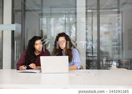 Diverse colleagues working together on laptop at conference table Diverse colleagues working together on laptop at conference table 143291165