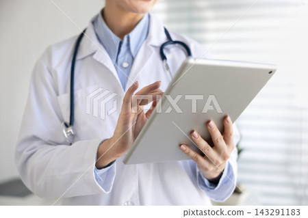 Doctor reviewing patient data on digital tablet, crop closeup view Doctor reviewing patient data on digital tablet, crop closeup view 143291183