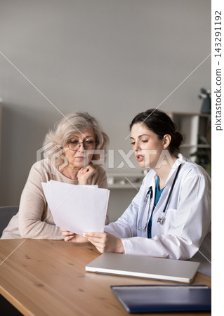 Doctor explaining insurance terms or treatment plan to senior woman Doctor explaining insurance terms or treatment plan to senior woman 143291192