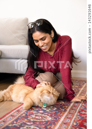 Indian woman playing with fluffy cat at home Indian woman playing with fluffy cat at home 143291646