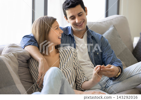 Young couple enjoying casual talk seated on sofa Young couple enjoying casual talk seated on sofa 143292016