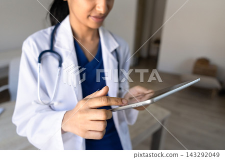 Closeup female doctor working on digital tablet in clinic office Closeup female doctor working on digital tablet in clinic office 143292049