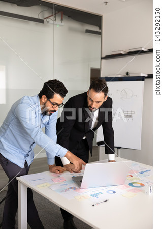 Colleagues working together on marketing strategy using laptop 143292150