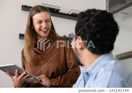 Female laughing, engaging in positive informal conversation with colleague Female laughing, engaging in positive informal conversation with colleague 143292194