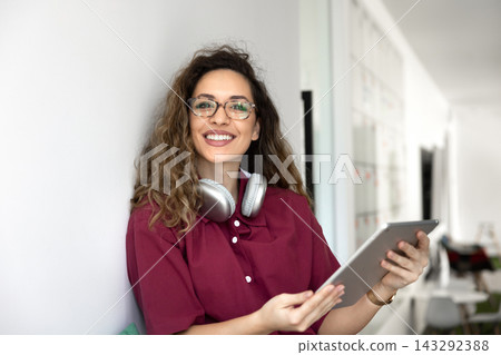 Female freelancer sitting in coworking using digital tablet, portrait Female freelancer sitting in coworking using digital tablet, portrait 143292388