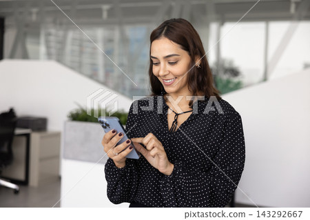 Positive young business company worker woman typing on mobile phone Positive young business company worker woman typing on mobile phone 143292667