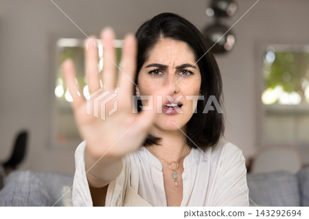 Anxious scared young Hispanic woman showing hand stop at camera 143292694