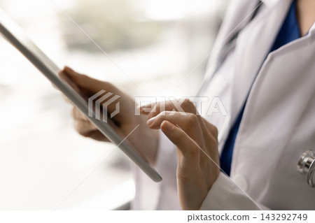 Closeup of female doctor hands holding digital tablet Closeup of female doctor hands holding digital tablet 143292749