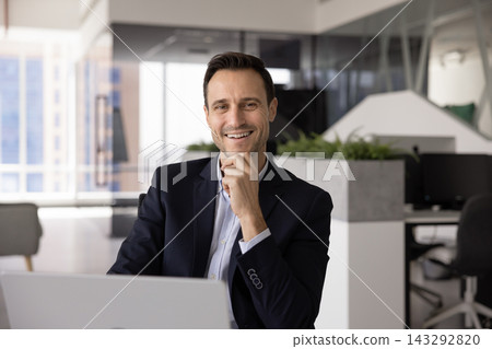 Portrait Hispanic male executive working on laptop at office desk Portrait Hispanic male executive working on laptop at office desk 143292820
