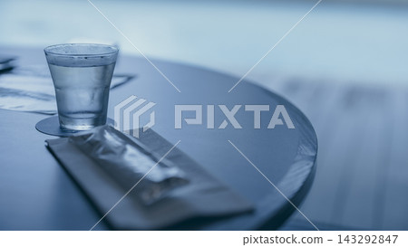 桌上放著一杯水,背景是游泳池。 桌上放著一杯水,背景是游泳池。 143292847