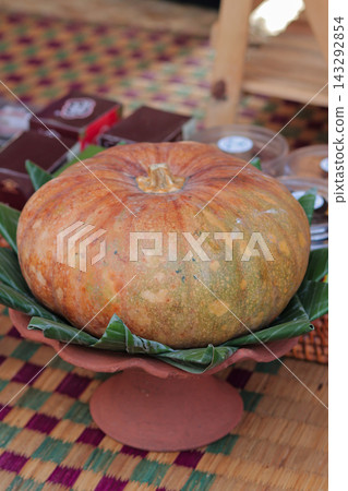 Big orange pumpkin on clay platter 143292854