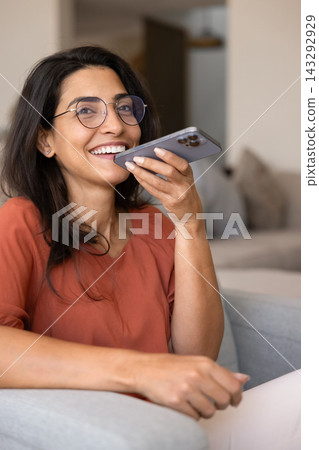 Happy woman using voice assistant on smartphone 143292929