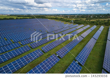 Aerial view of large sustainable electrical power plant with rows of solar photovoltaic panels for producing clean electric energy. Concept of renewable electricity with zero emission Aerial view of large sustainable electrical power plant with rows of solar photovoltaic panels for producing clean electric energy. Concept of renewable electricity with zero emission 143293038