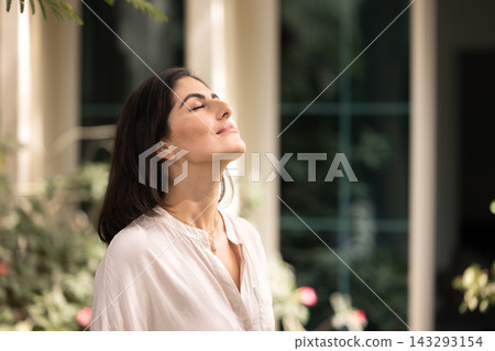 Peaceful calm young Hispanic woman taking deep breath outside Peaceful calm young Hispanic woman taking deep breath outside 143293154