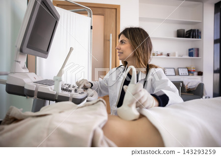 Female doctor performs abdominal ultrasound scan to young woman patient Female doctor performs abdominal ultrasound scan to young woman patient 143293259