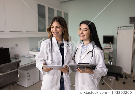 Two doctors in white coats engaged in medical team briefing Two doctors in white coats engaged in medical team briefing 143293260