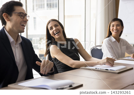 Joyful multicultural office workers laugh on funny joke on briefing Joyful multicultural office workers laugh on funny joke on briefing 143293261