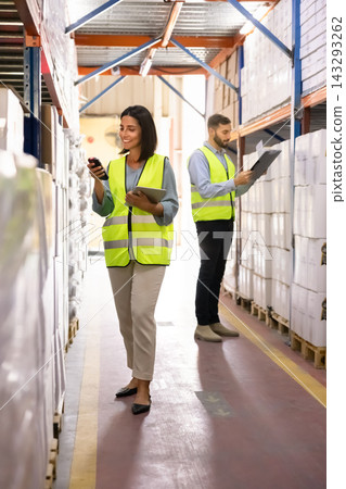 Two warehouse workers checking inventory on shelves stockroom storage Two warehouse workers checking inventory on shelves stockroom storage 143293262