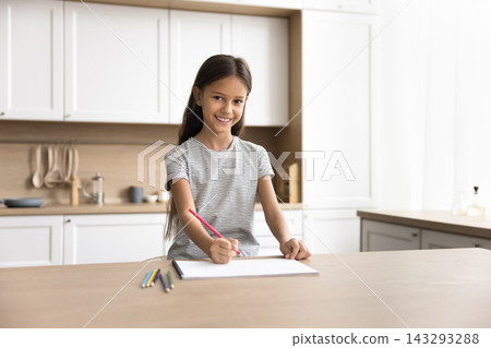 Little girl holds pencil and draws in paper sketchbook Little girl holds pencil and draws in paper sketchbook 143293288