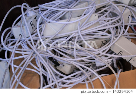 Tangled pile of white extension cables Tangled pile of white extension cables 143294104