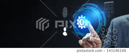 Businessman interacting with a futuristic digital interface showing security icons, a gear with a keyhole, and graphical UI elements against a dark background. Cybersecurity concept 143296198