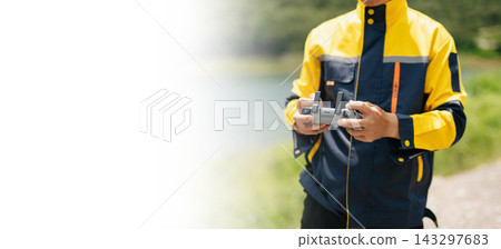 Asian engineer in hardhat landing a drone on his hand near wind turbines for renewable energy site inspection and survey. Asian engineer in hardhat landing a drone on his hand near wind turbines for renewable energy site inspection and survey. 143297683