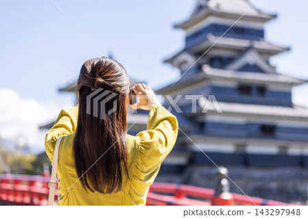 A woman taking pictures of a castle A woman taking pictures of a castle 143297948