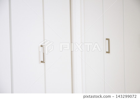 Simple interior with white storage doors and handles. Simple interior with white storage doors and handles. 143299072