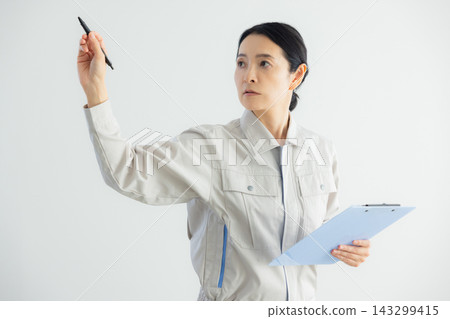 一位身穿工作服的中年婦女,她很擔憂。 一位身穿工作服的中年婦女,她很擔憂。 143299415