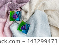 Laundry detergent pods on clean folded towels 143299473