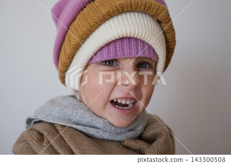 girl making scary face reaching hands towards camera in warm winter beanies girl making scary face reaching hands towards camera in warm winter beanies 143300508