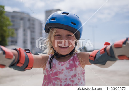 Little Girl Wearing a Helmet and Protective Gear Little Girl Wearing a Helmet and Protective Gear 143300672