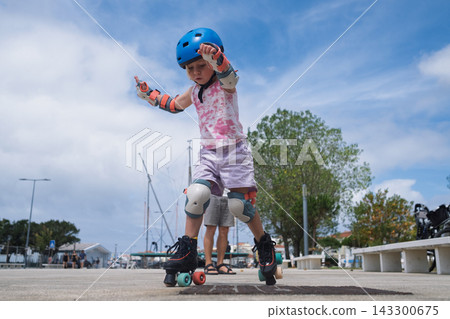 Cute Blonde Toddler in Safety Equipment Giving Thumbs Up Gesture Outdoors 143300675