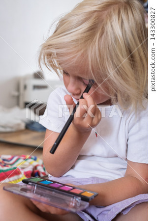 Little Girl Applying Makeup with a Brush at Home Little Girl Applying Makeup with a Brush at Home 143300827