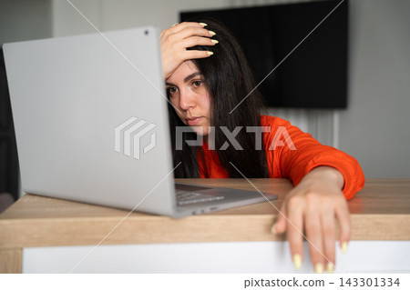 Tired woman resting her head while working on laptop at home desk. Remote work wellbeing screen break and digital fatigue awareness Tired woman resting her head while working on laptop at home desk. Remote work wellbeing screen break and digital fatigue awareness 143301334