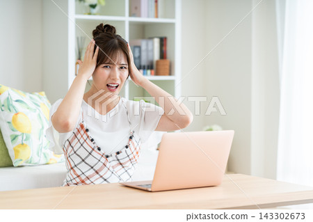 一個年輕女子擔心一台電腦 一個年輕女子擔心一台電腦 143302673