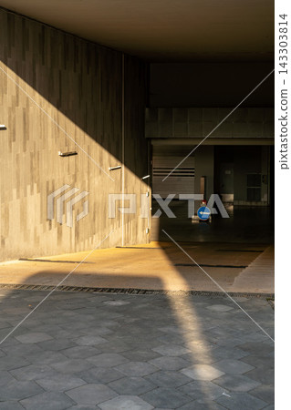 Sunlit Modern Parking Garage Entrance With Diagonal Shadow, Concrete Walls And Directional Arrow Sunlit Modern Parking Garage Entrance With Diagonal Shadow, Concrete Walls And Directional Arrow 143303814