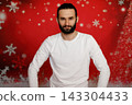 Serious man looking at camera on Christmas background 143304433