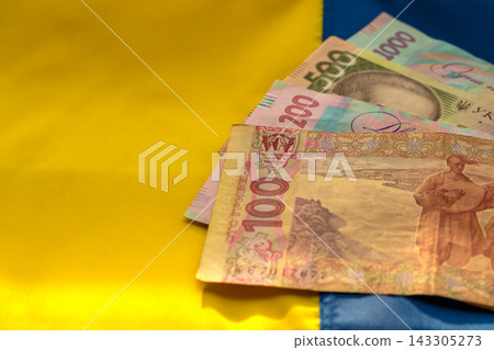 Ukrainian hryvnia banknote on national flag representing money, finance and economy Ukrainian hryvnia banknote on national flag representing money, finance and economy 143305273