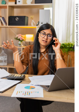 Indian woman on home table calls about billing error and discusses wrong charge on receipt by phone Indian woman on home table calls about billing error and discusses wrong charge on receipt by phone 143306428