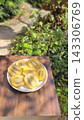 A plate piled high with fresh, juicy sliced gold kiwis against a green background. 143306769
