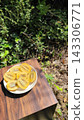 A plate piled high with fresh, juicy sliced gold kiwis against a green background. 143306771