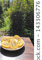 A plate piled high with fresh, juicy sliced gold kiwis against a green background. 143306776